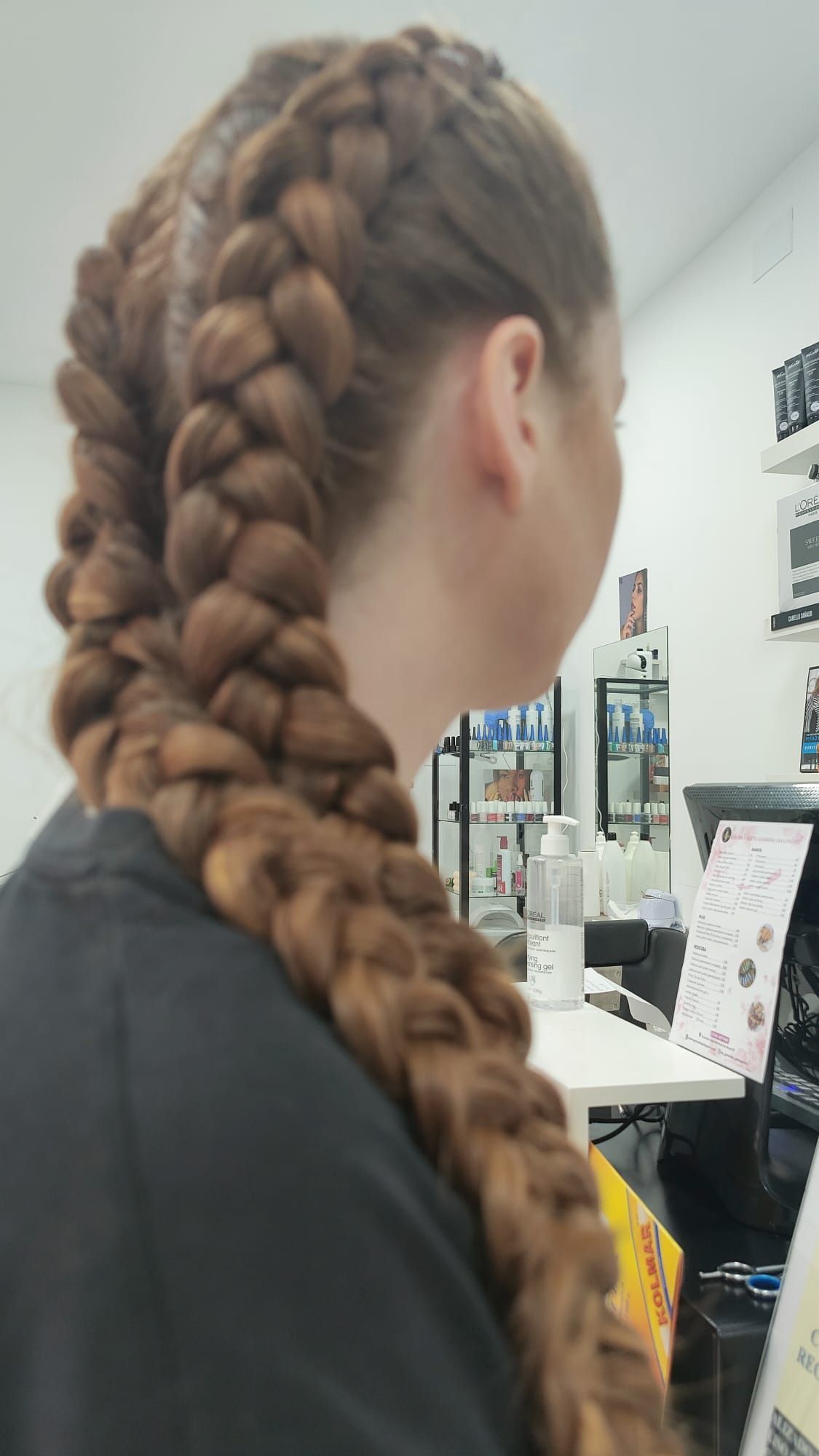 Una mujer con cabello largo lleva una cola de caballo trenzada.