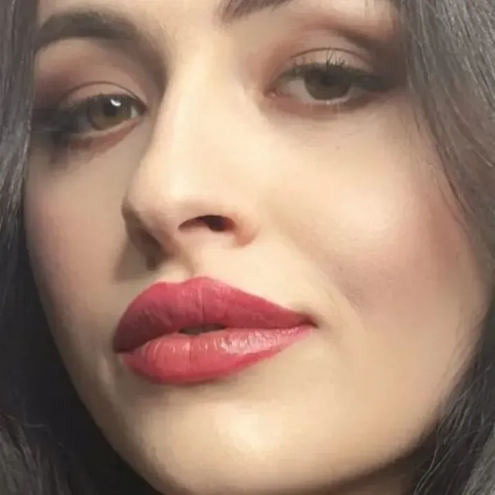 Un primer plano del rostro de una mujer con lápiz labial rojo.