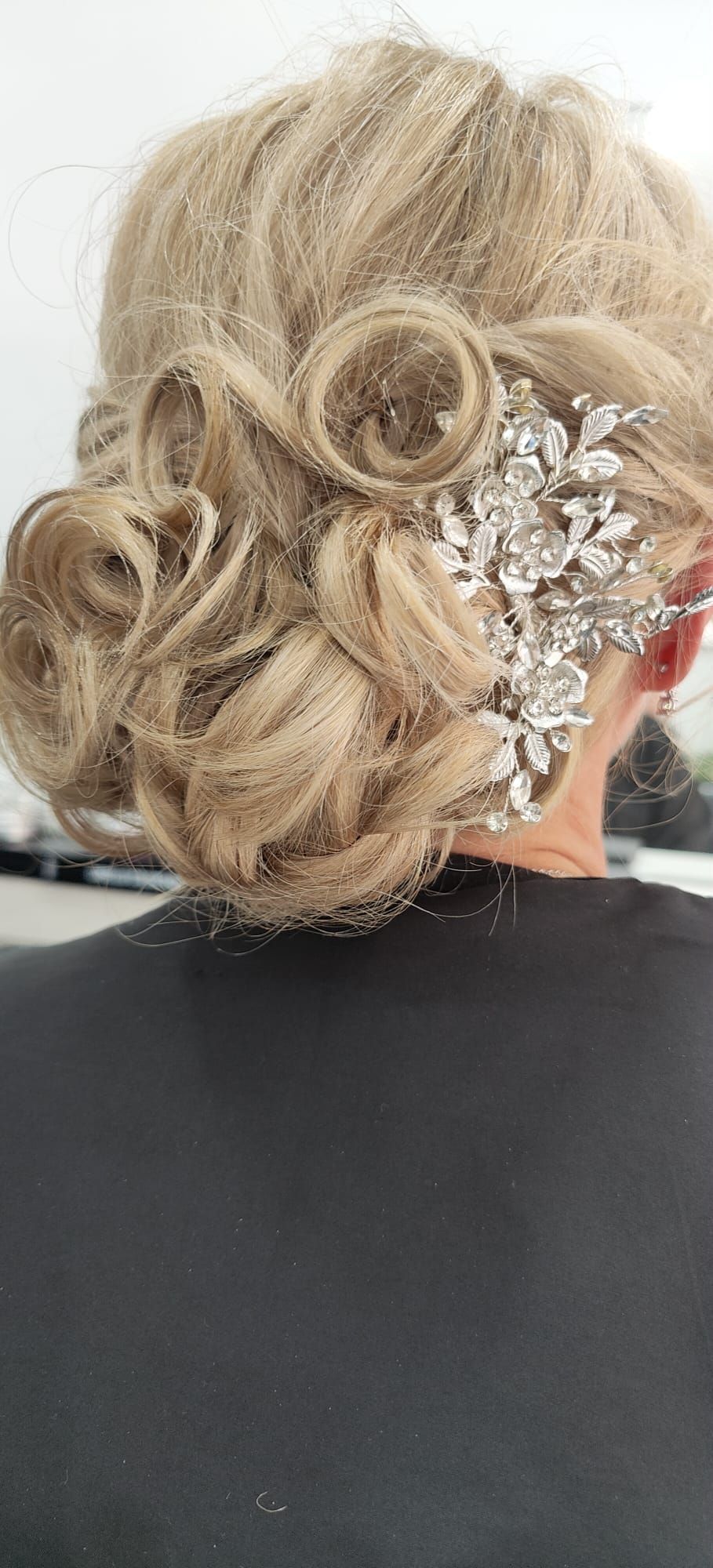 Una mujer lleva un moño con un peine en el pelo.