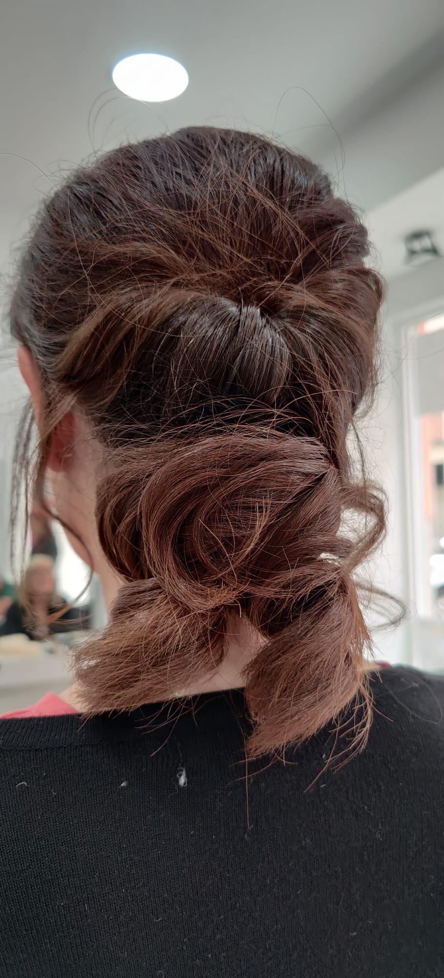 Una mujer se está peinando en un salón.
