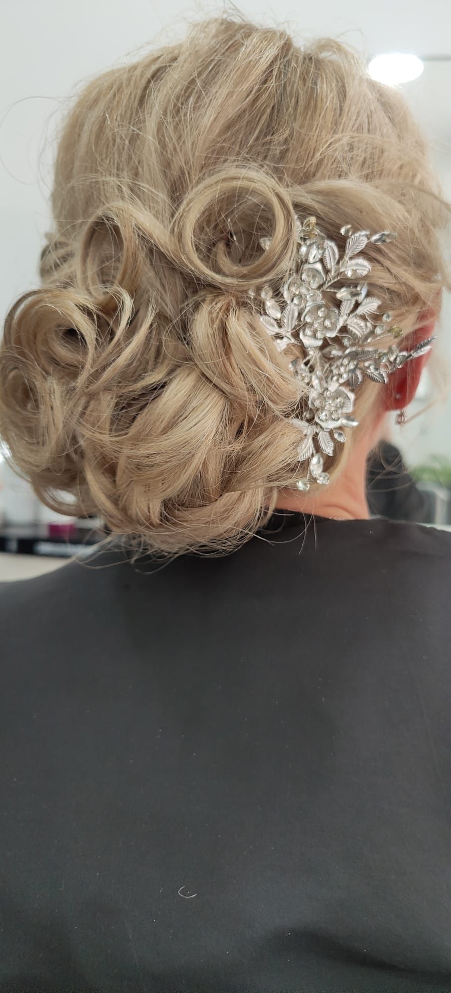 Una mujer lleva un moño con un peine en el pelo.