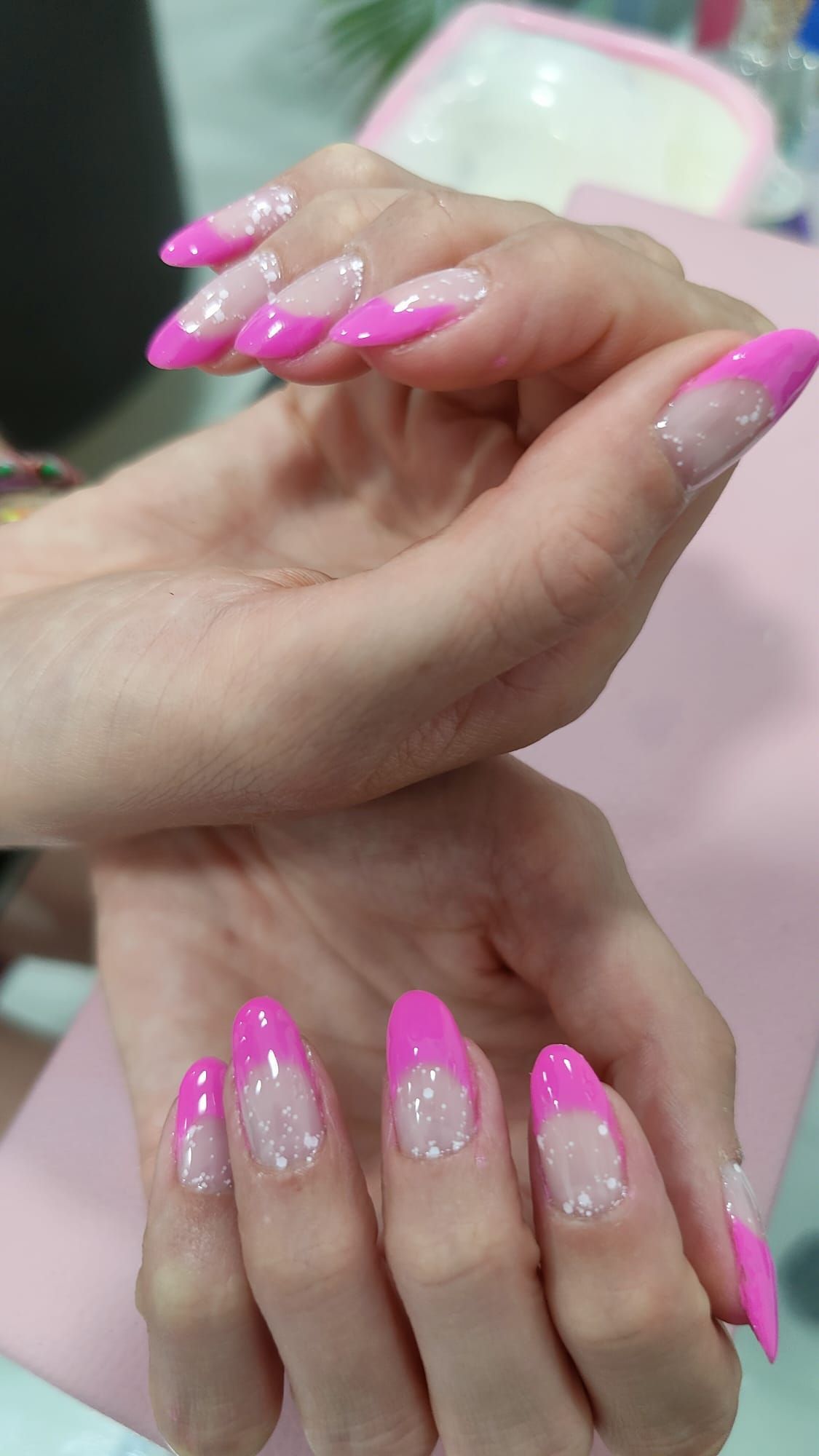 Un primer plano de las manos de una mujer con uñas rosas.