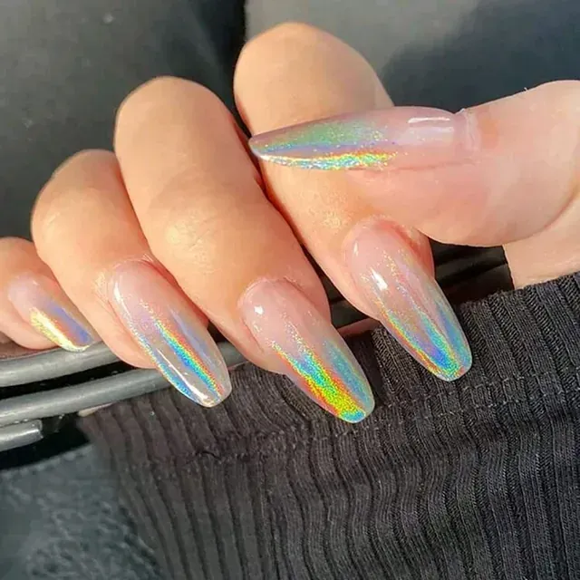 Un primer plano de las uñas de una mujer sosteniendo un frasco de brillantina.