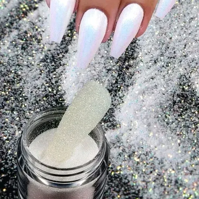 Un primer plano de las uñas de una mujer sosteniendo un frasco de brillantina.
