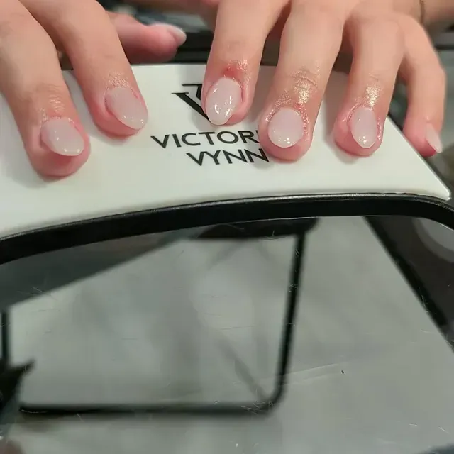Un primer plano de las uñas de una persona sobre un cojín de Victor Vynn.