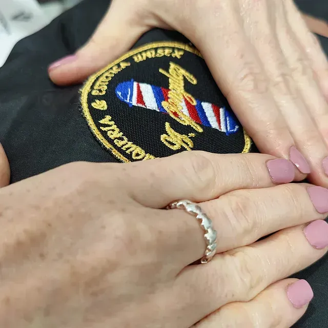 Un primer plano de la mano de una persona con un anillo en ella.