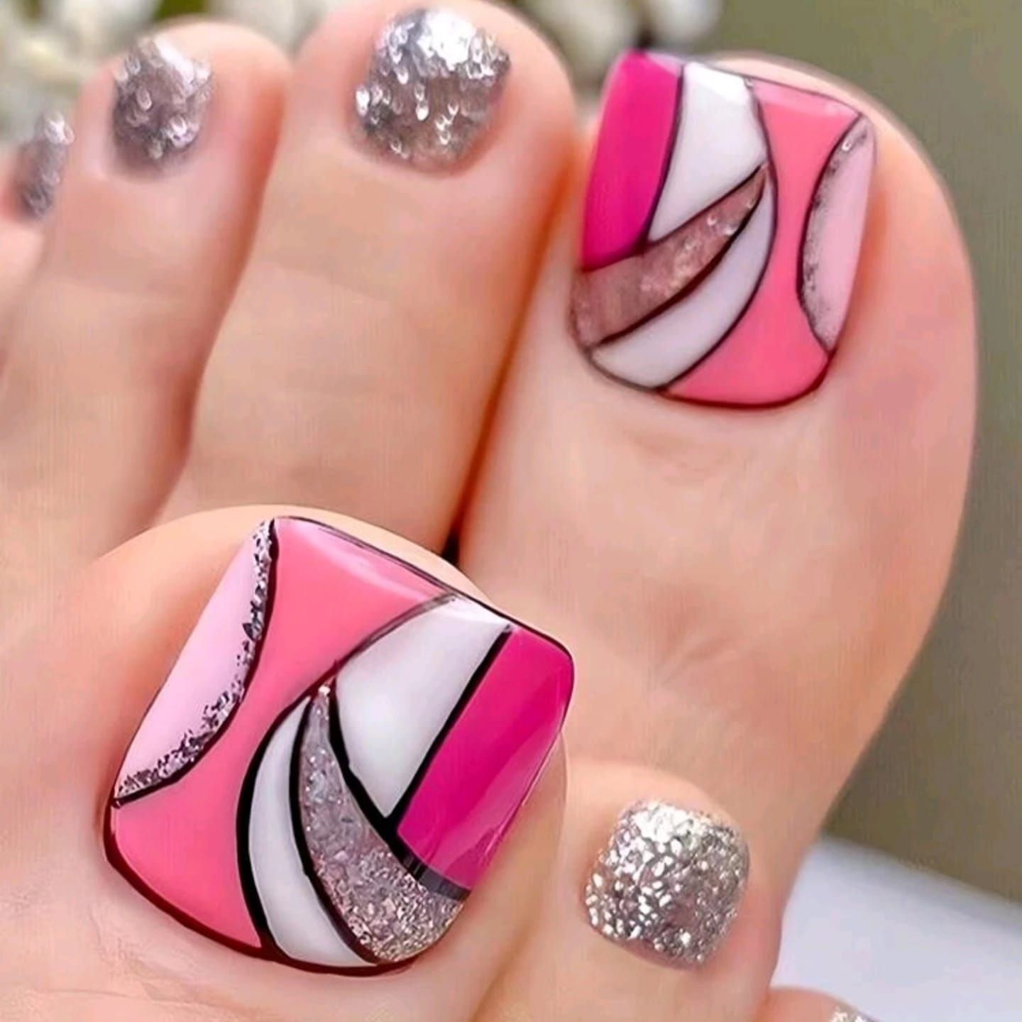Un primer plano de las uñas de los pies de una mujer con un diseño rosa y blanco.