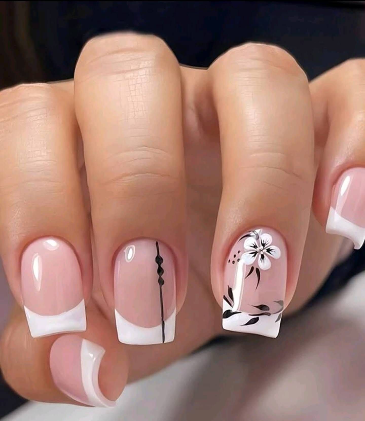 Un primer plano de las uñas de una mujer con un diseño floral.