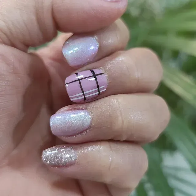 Un primer plano de las uñas de una persona con un diseño a cuadros.