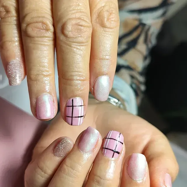 Un primer plano de las uñas de una mujer con un diseño de cuadros.