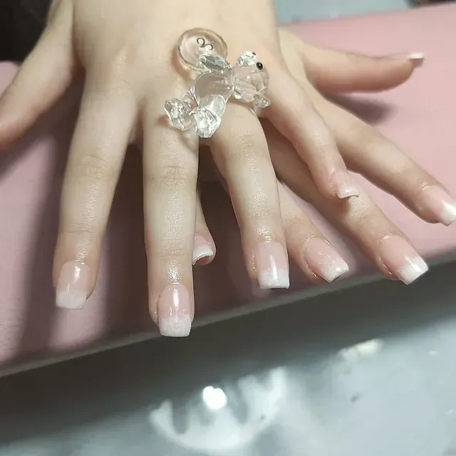 Un primer plano de la mano de una mujer con un anillo en el dedo.