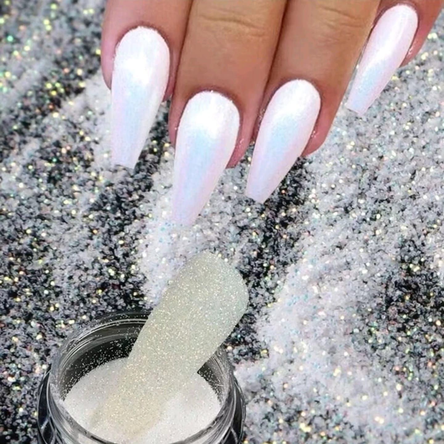 Un primer plano de las uñas de una mujer y un frasco de brillantina.