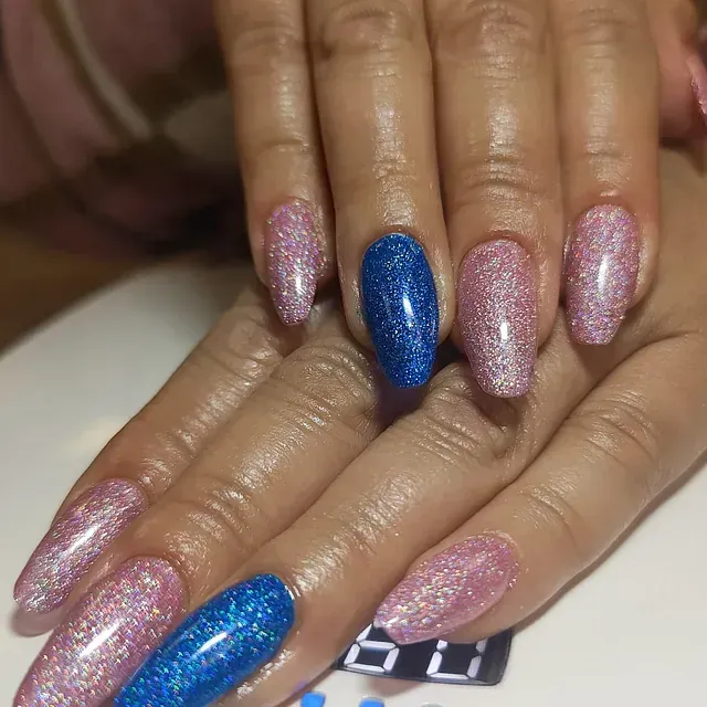 Un primer plano de las manos de una mujer con uñas azules y rosas.