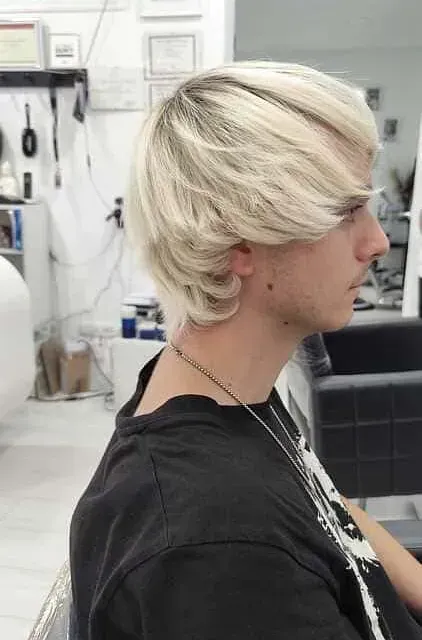 Un hombre con cabello rubio lleva una camisa negra.