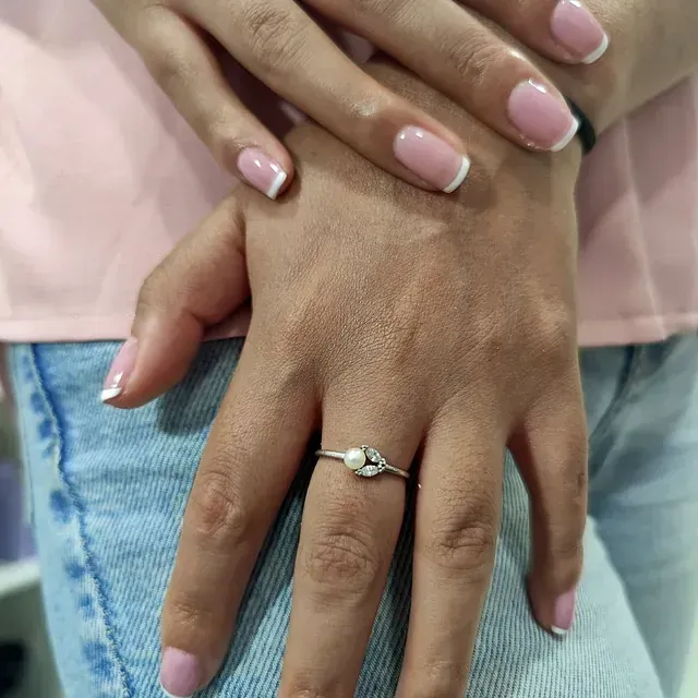 Un primer plano de la mano de una mujer con un anillo en ella.
