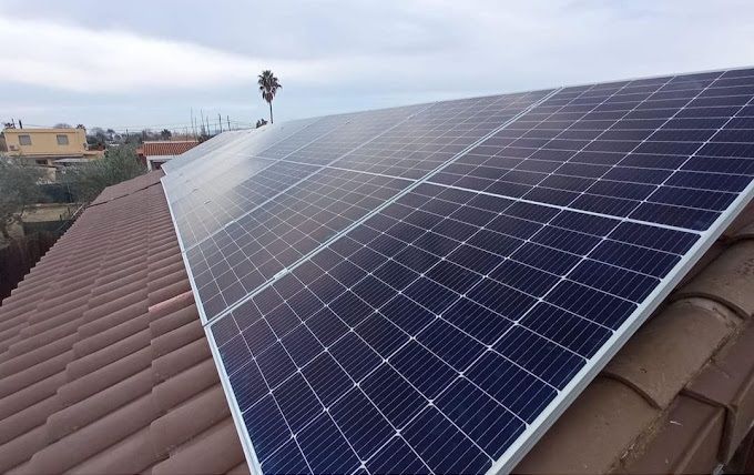 Paneles solares instalados en un techo de tejas marrones, captando la luz solar.