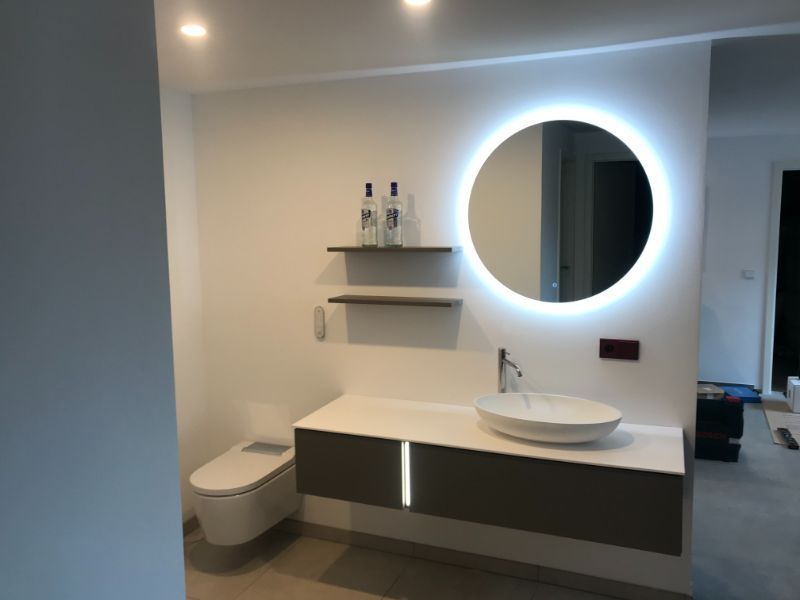 Badezimmer mit beleuchtetem Spiegel über dem Waschbecken