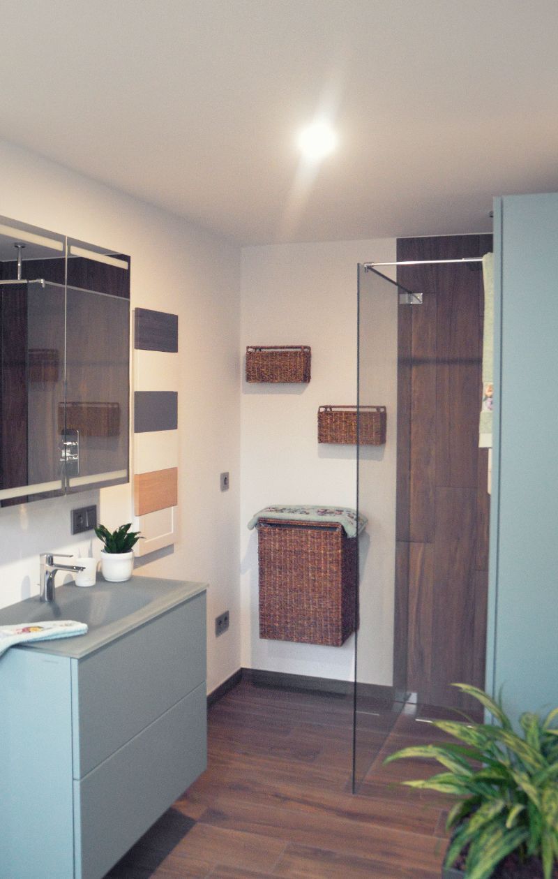 Badezimmer mit Holzboden und hellblauen Badezimmermöbeln