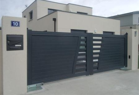 Maison moderne avec portail coulissant gris foncé, boîte aux lettres et numéro 10.