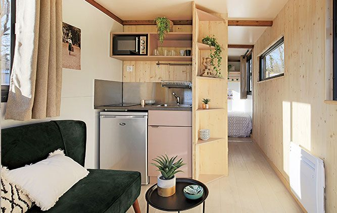 Petit coin cuisine moderne avec lambris clair, placards et micro-ondes