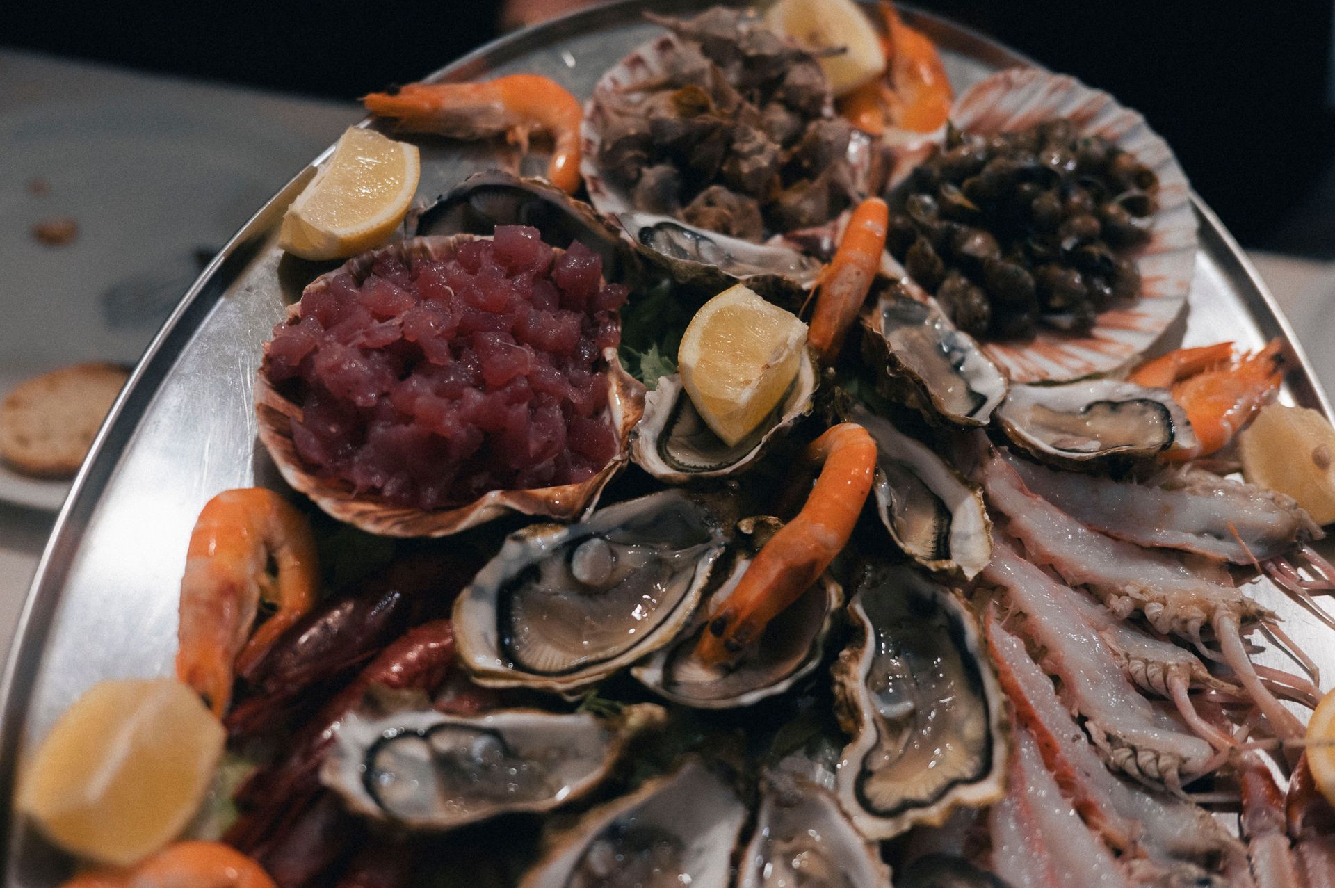 Plateau de fruits de mer avec huîtres, moules, crevettes et quartiers de citron sur un plateau en métal