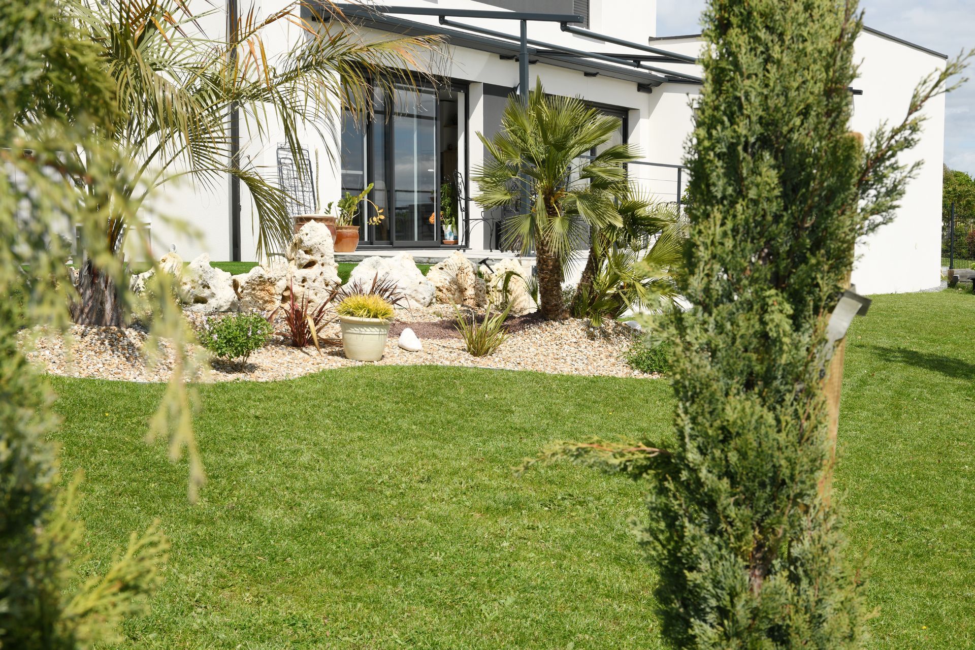 Terrasse avec auvent bordé d'un aménagement paysager