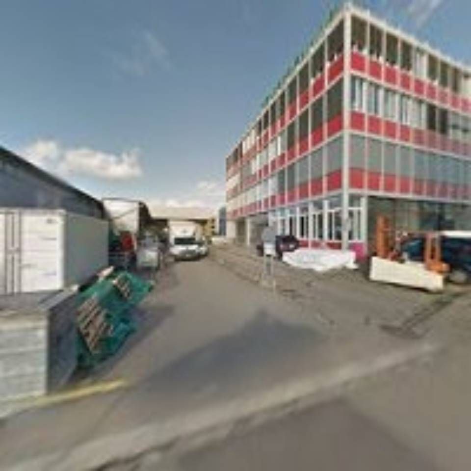 Rot-weißes mehrstöckiges Gebäude mit Ladefläche, Fahrzeugen und Ausrüstung.