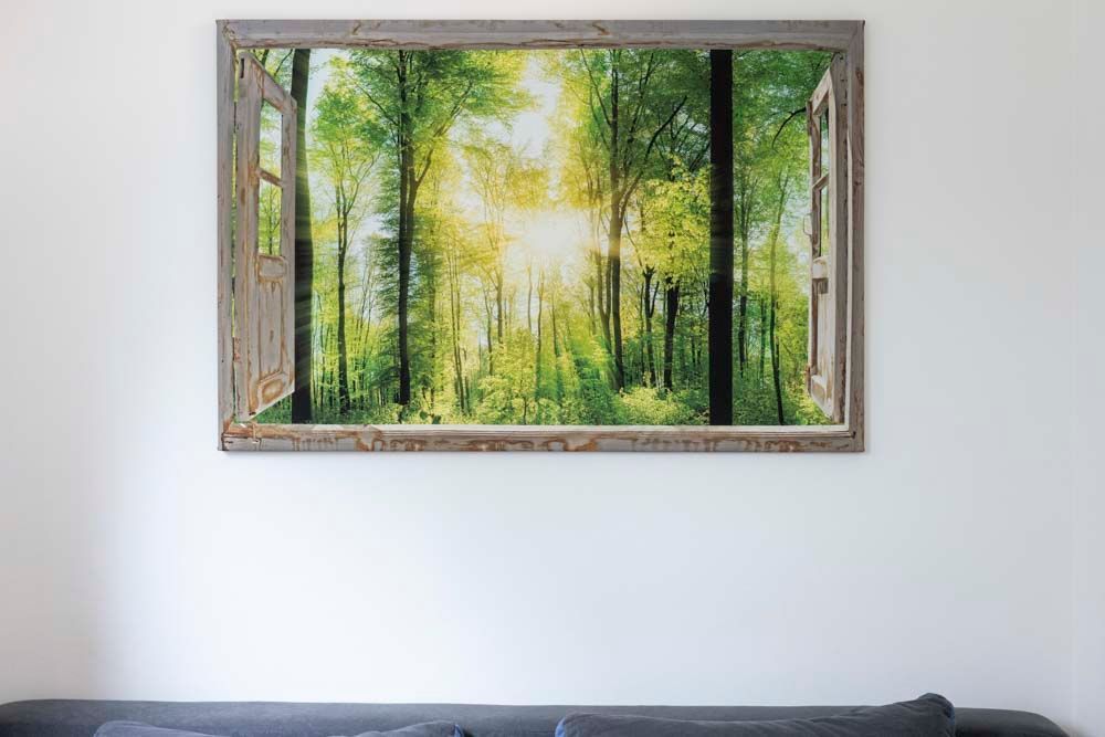 An einer Wand in einem Wohnzimmer hängt ein Gemälde eines Waldes.