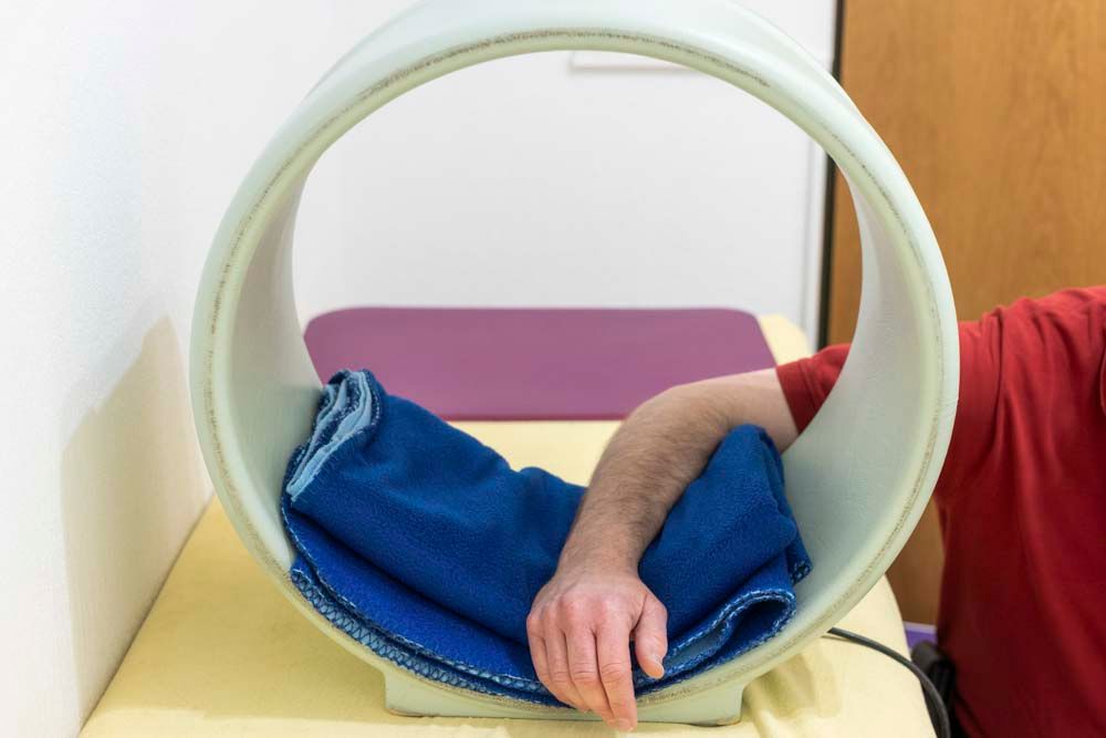Ein Mann erhält eine Magnetfeldtherapie-Behandlung am Arm.