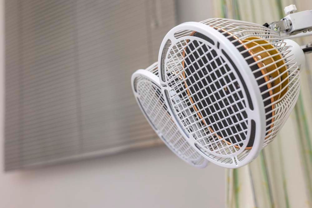 Eine Nahaufnahme eines Ventilators, der in einem Raum von der Decke hängt.