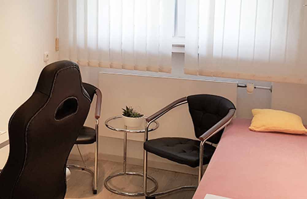 Im Zimmer gibt es einen Stuhl und einen Tisch.