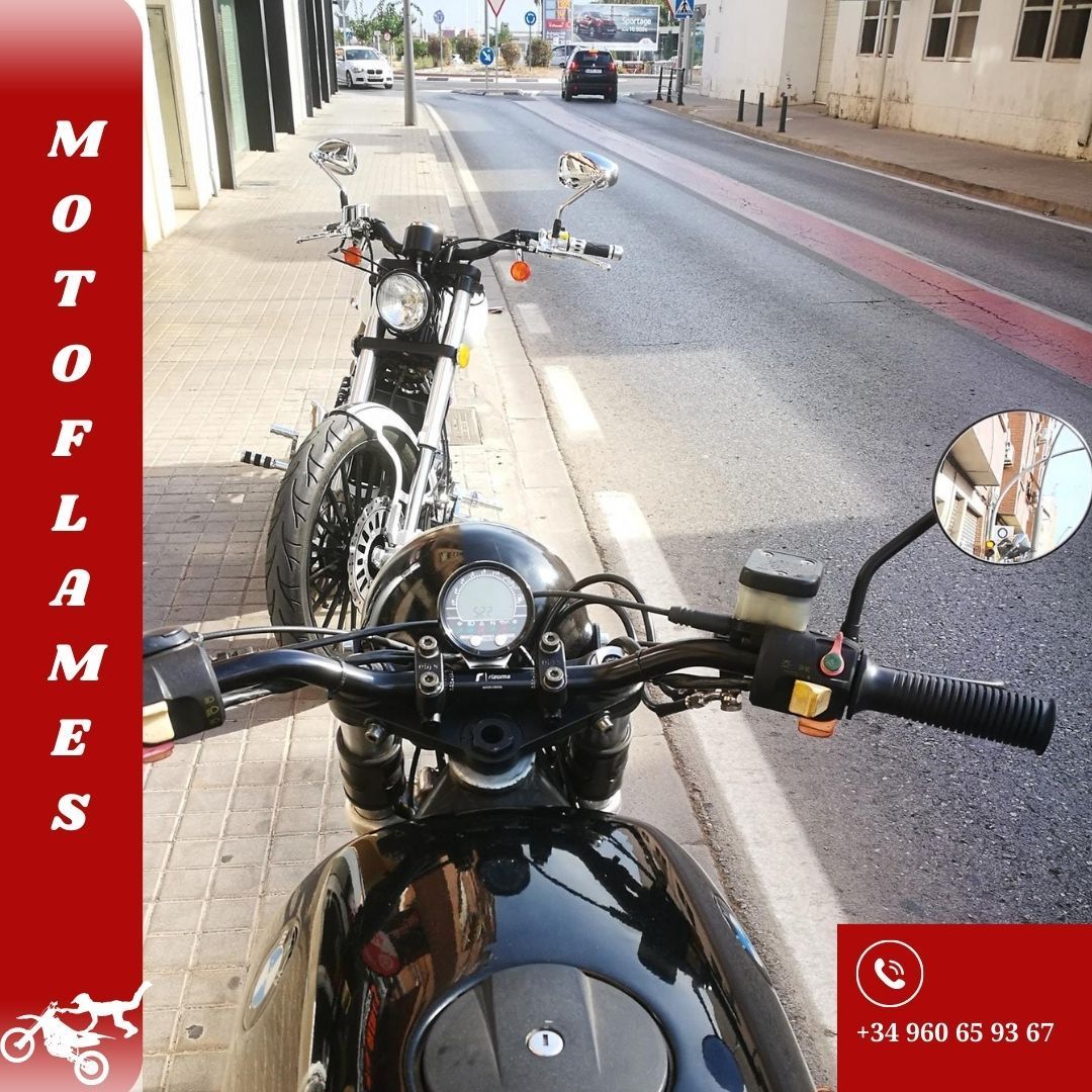 Dos motocicletas están estacionadas al costado de la carretera con un logo de Moto Flames en la esquina.