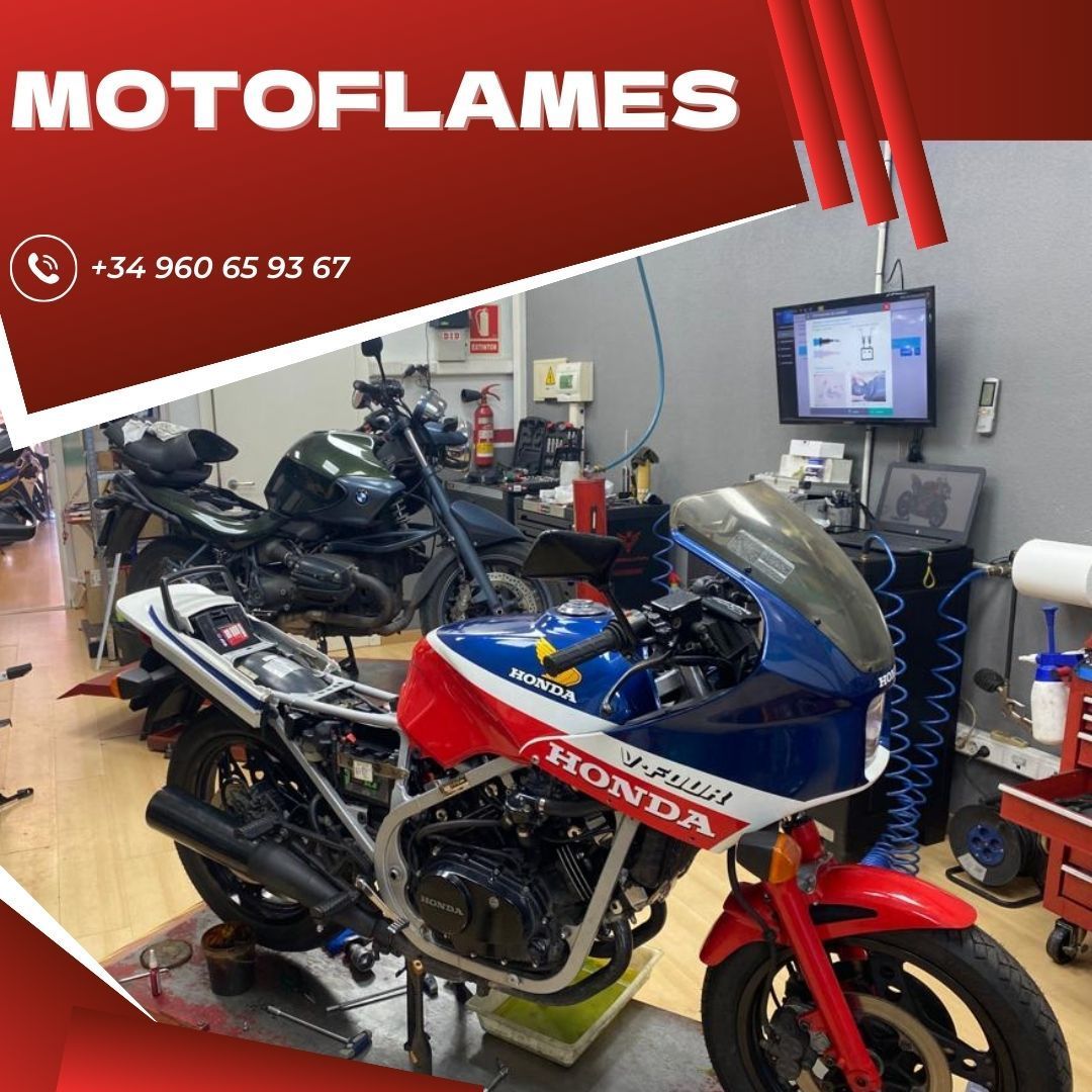 Una motocicleta Honda roja, blanca y azul está estacionada en un garaje.