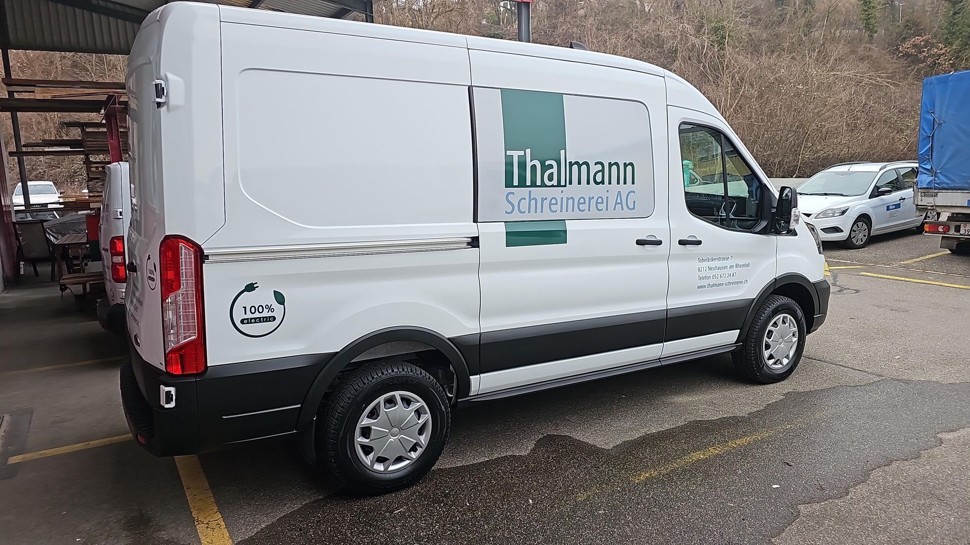 Holzfassade eines modernen Hauses mit natürlicher Holzverkleidung. Ausgestattet mit Fenster, Terrasse und Grünflächen.