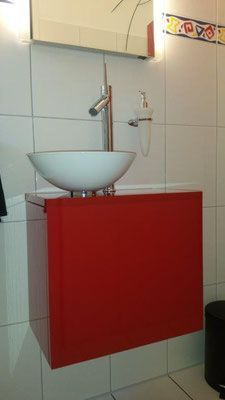 Roter Waschtisch mit weissem Aufsatzwaschbecken und verchromter Armatur.