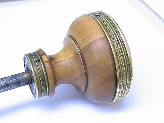 Türknauf aus Holz mit Messingbeschlägen und Metallstange.
