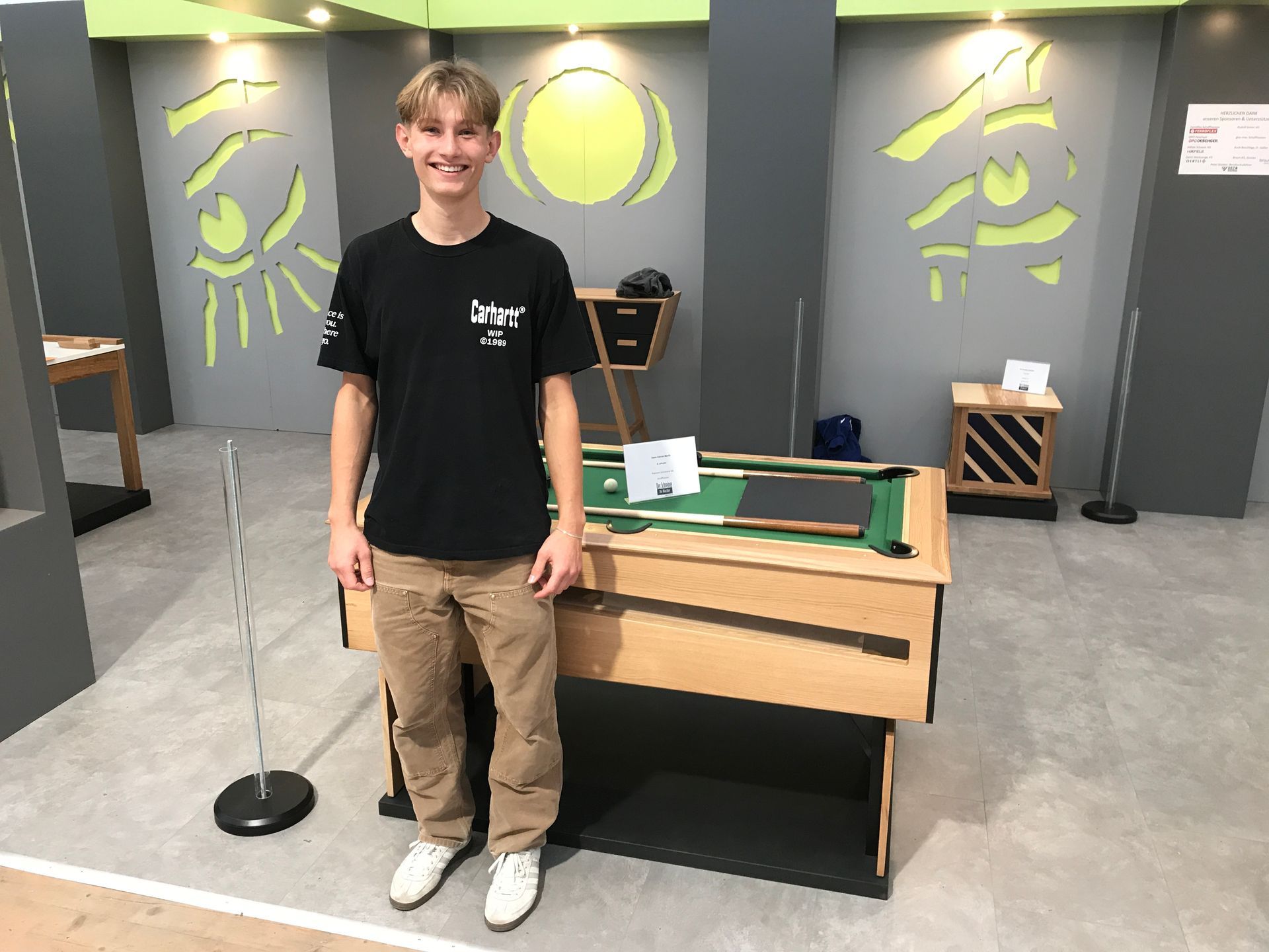 Eine Person montiert mit einem Schraubenzieher einen Holzschrank.