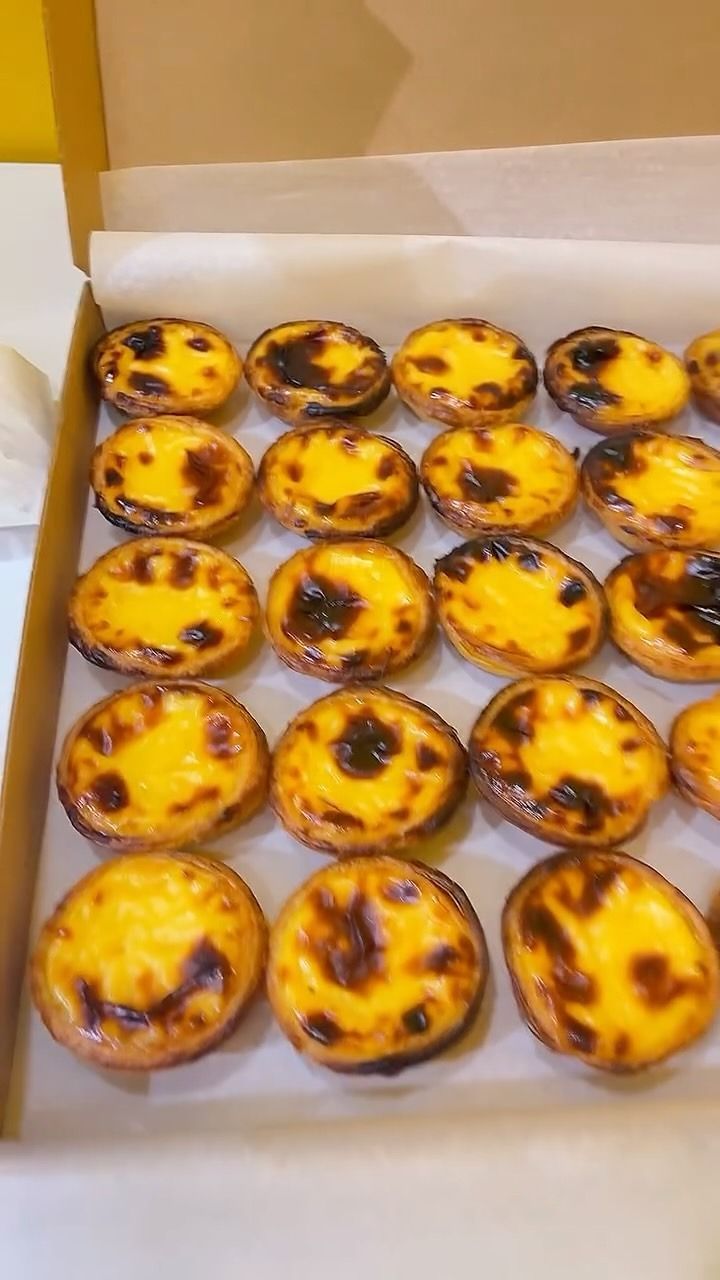 Una caja llena de una variedad de pasteles sobre una mesa.