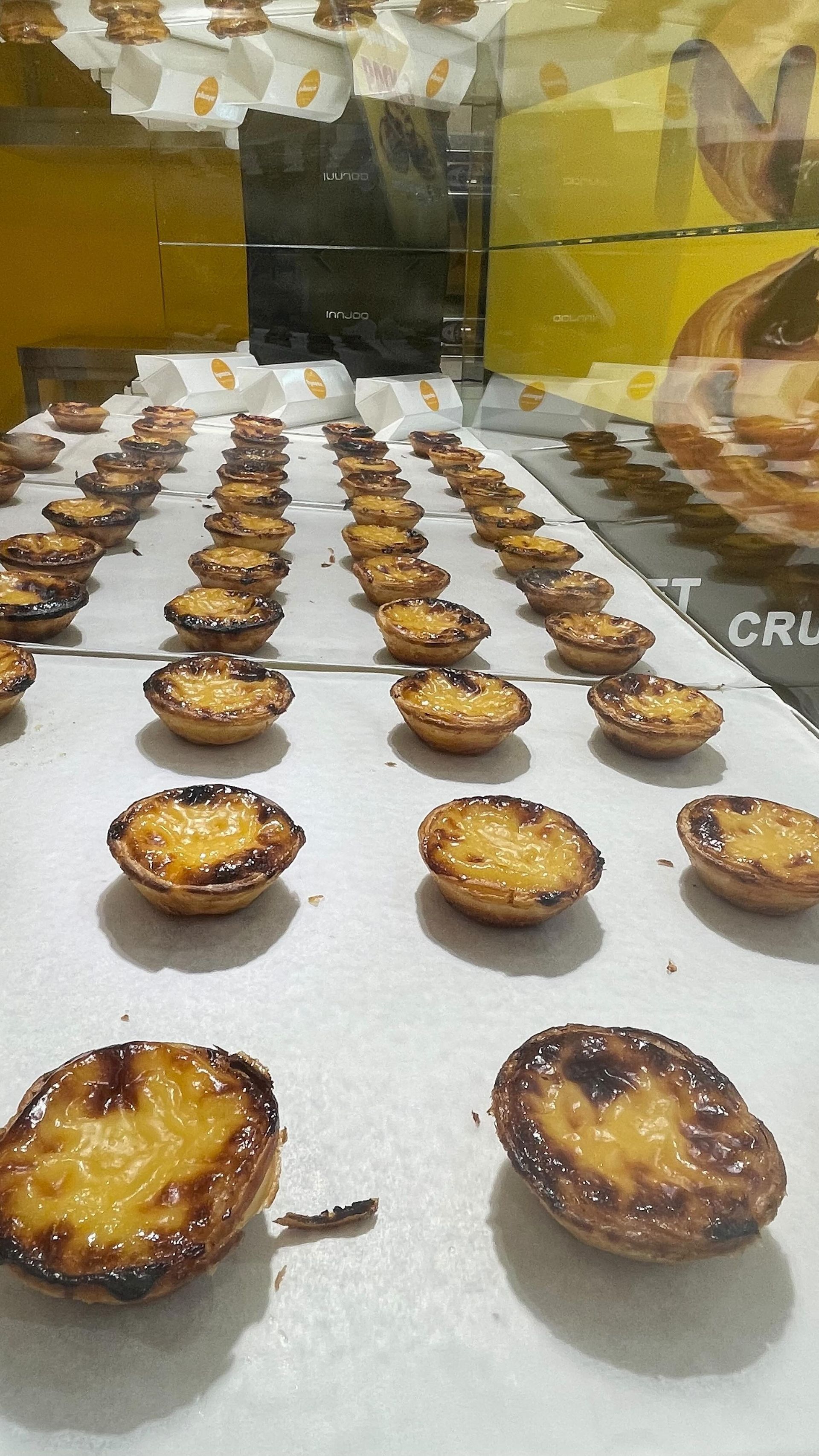 Un montón de pasteles están sobre una mesa en una panadería.