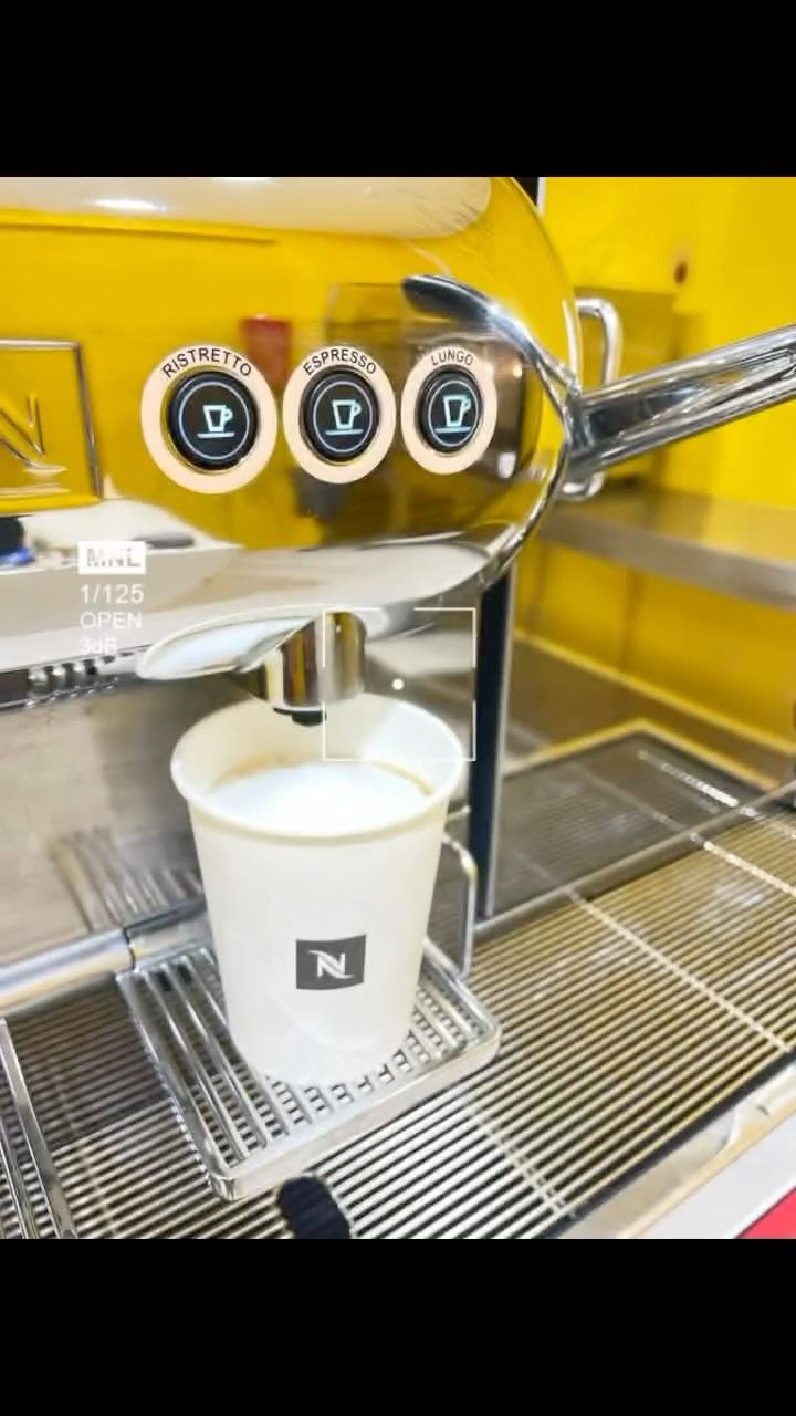 Se vierte una taza de café en una máquina de café.