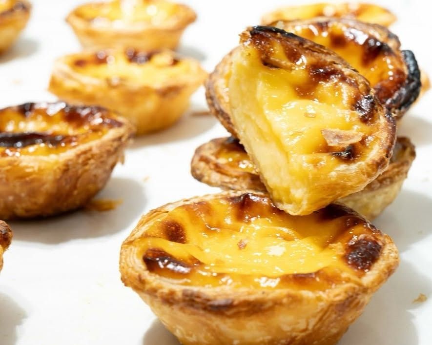Una pila de tartas de huevo a una de las cuales le falta un bocado