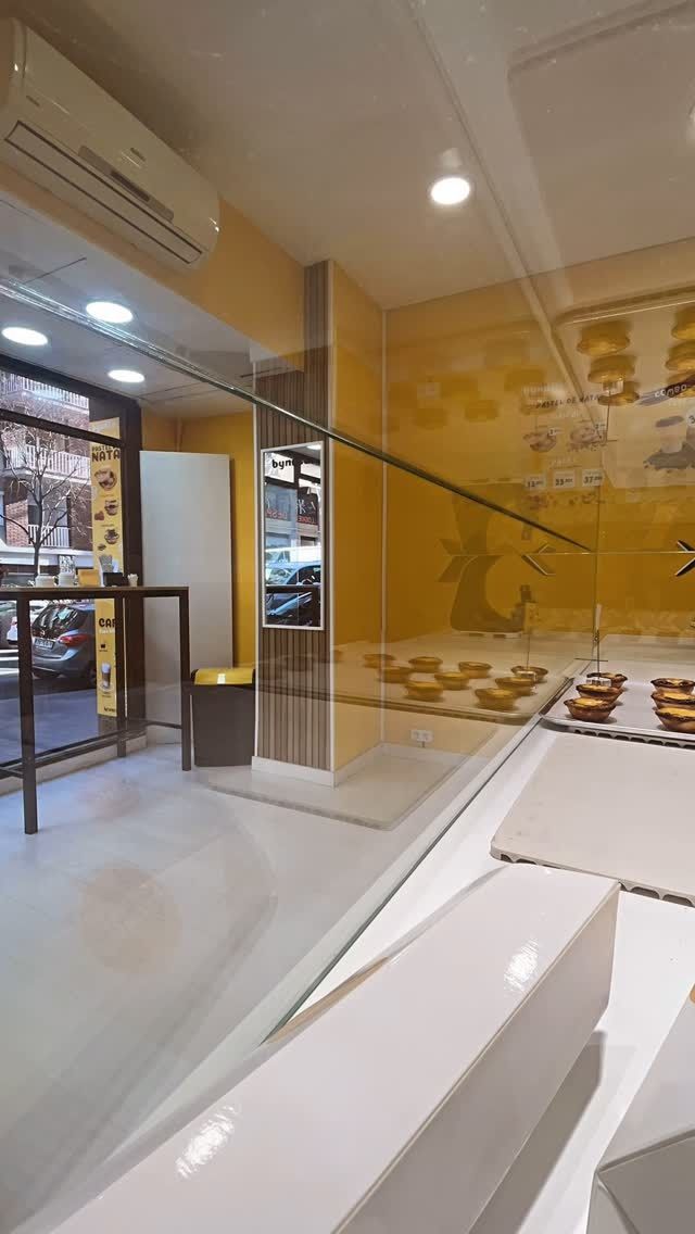 Una panadería con una pared amarilla y un mostrador blanco.