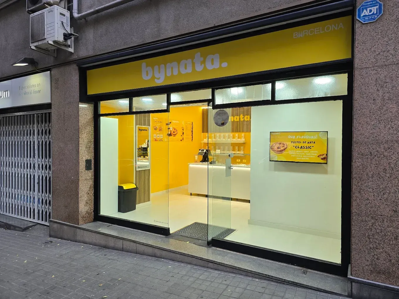 Un escaparate con un cartel amarillo que dice bynata