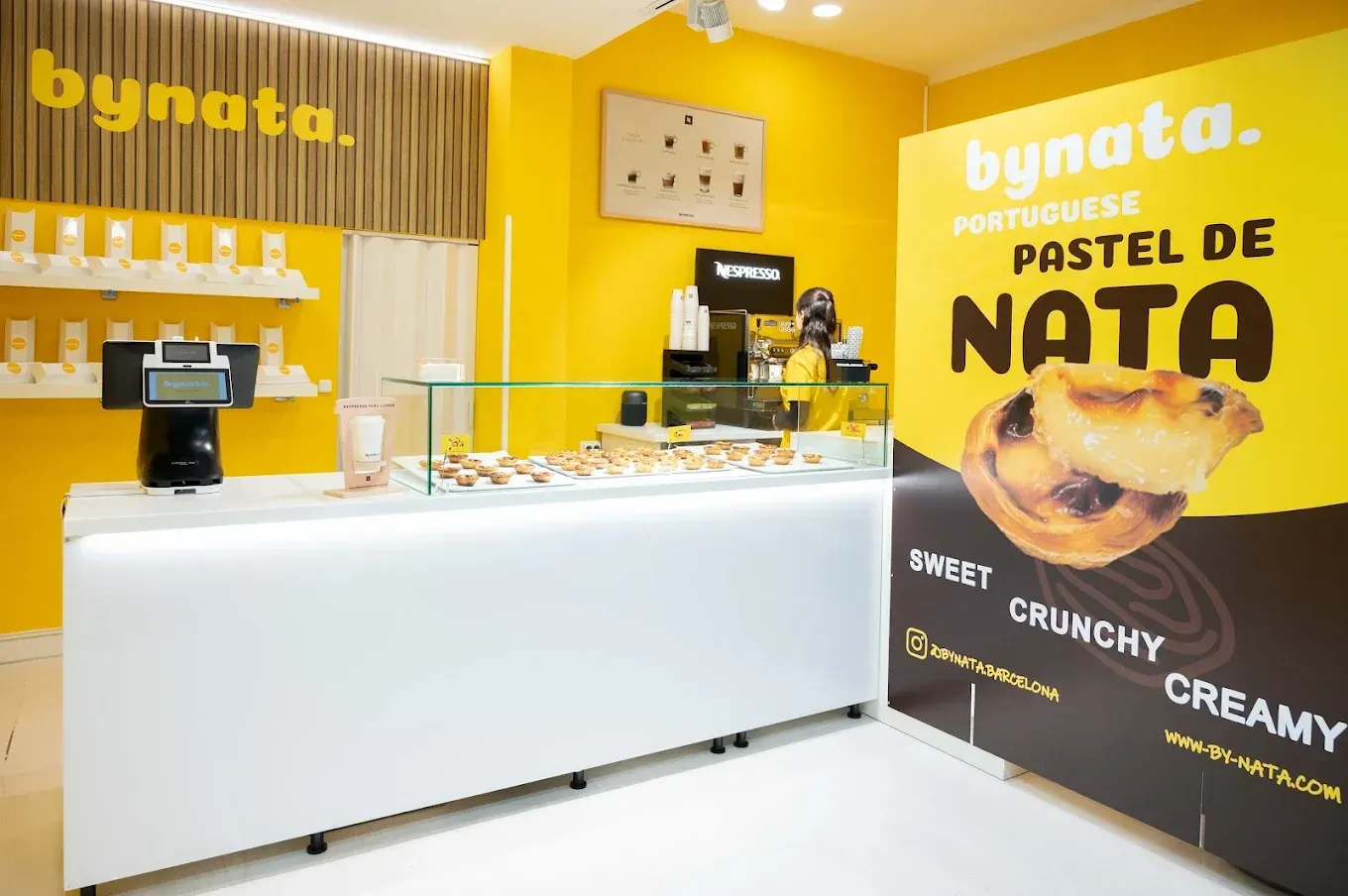Una pastelería con un cartel que dice bynata pastel de nata