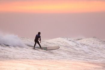 Una persona está montando una ola en una tabla de surf en el océano.