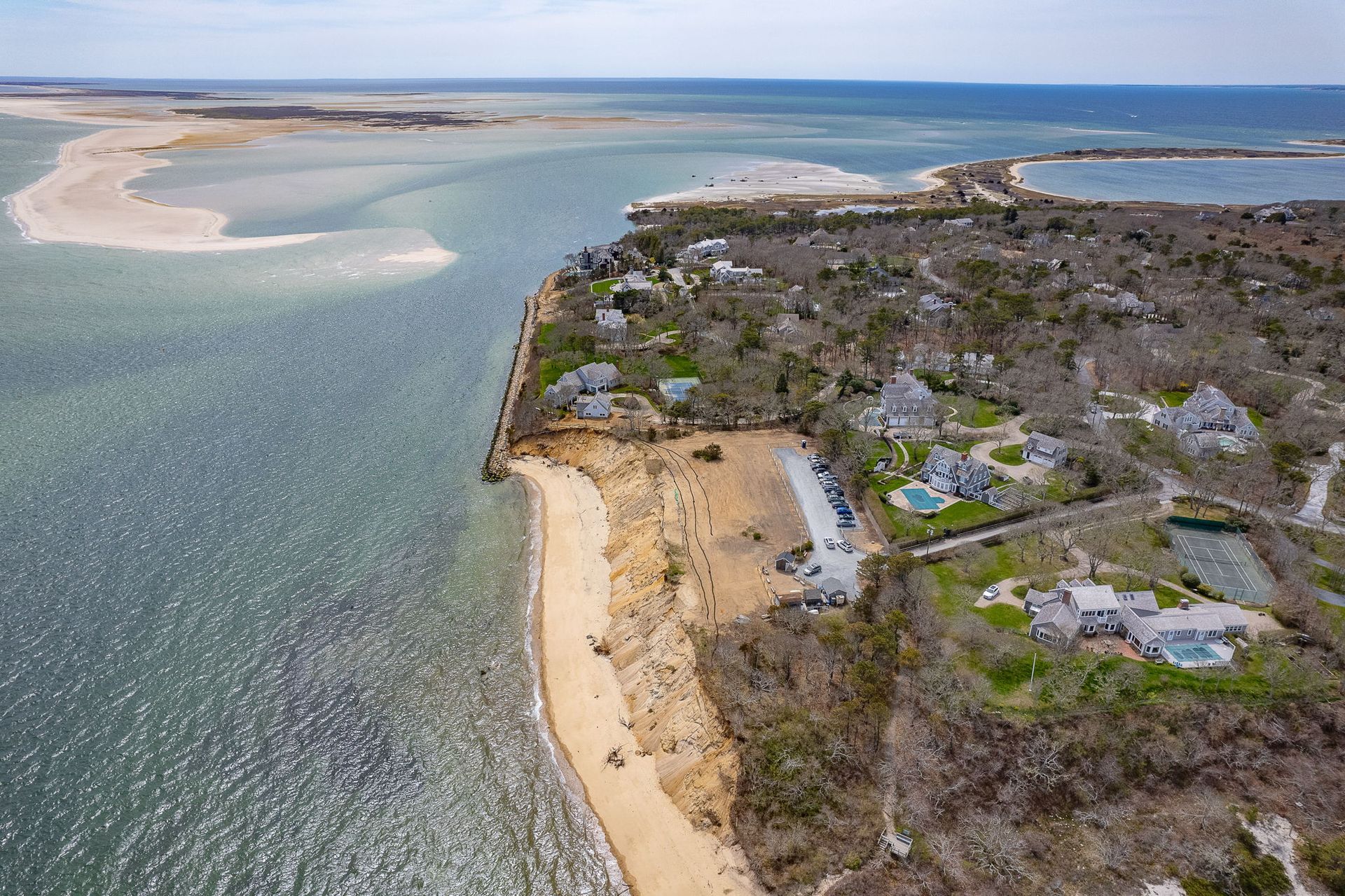 A wooden fence leading to a beach at sunset.