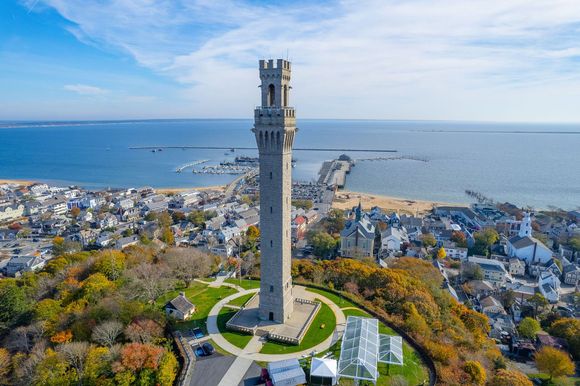 A porch with a couch and chairs and a view of the water.