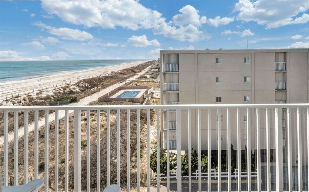 A balcony with a view of the ocean and a building.