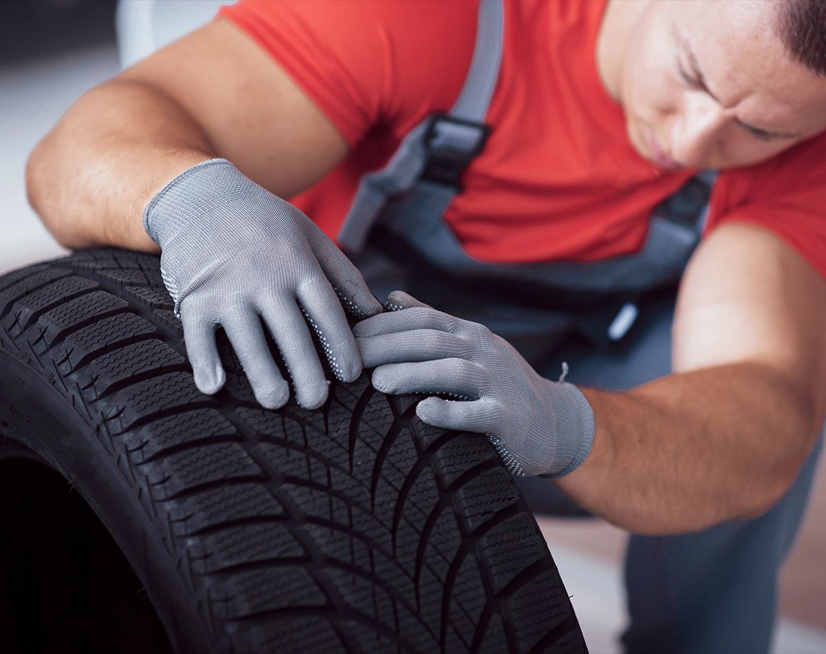 Garagiste posant les mains sur un pneu 