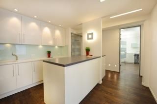 Eine Küche mit weißen Schränken und einem Holzboden